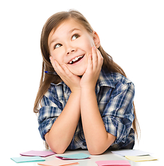 Image showing Girl is writing on color stickers using pen