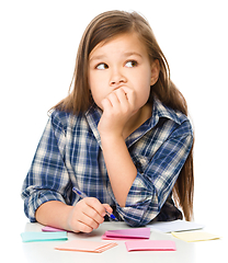 Image showing Girl is writing on color stickers using pen