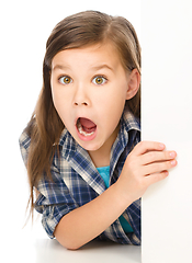 Image showing Little girl is looking out from the blank banner