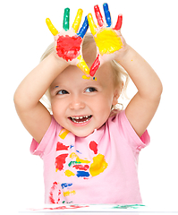 Image showing Portrait of a cute little girl playing with paints