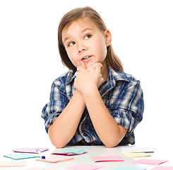 Image showing Girl is writing on color stickers using pen