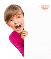 Image showing Little girl is looking out from the blank banner