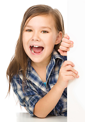 Image showing Little girl is looking from out blank board