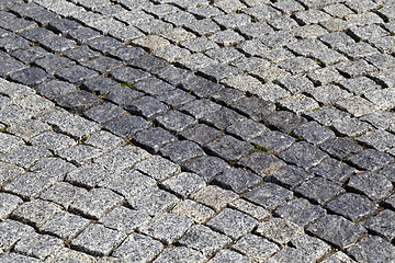 Image showing two different colors of the type of blocks paved bridge. photo close-up. Dark line lie diagonally