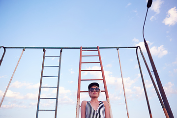 Image showing Beautiful woman in black and white striped swimsuit on the old sports ground. Film effect.