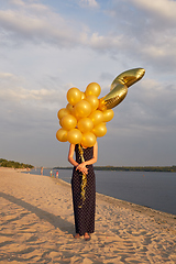 Image showing Young woman with many golden balloons.