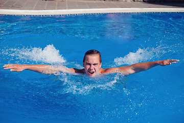 Image showing handsome boy swimming in outdoor pool