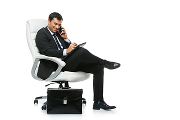 Image showing handsome businessman in suit sitting on armchair