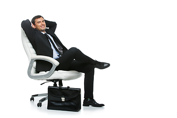 Image showing handsome businessman in suit sitting on armchair