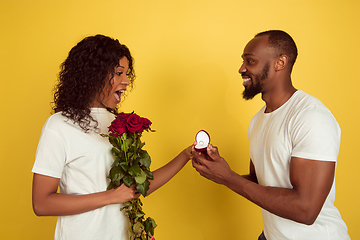 Image showing Valentine\'s day celebration, happy african-american couple isolated on yellow background