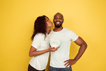 Image showing Valentine\'s day celebration, happy african-american couple isolated on yellow background