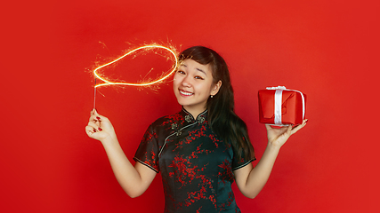 Image showing Happy Chinese New Year. Asian young girls\'s portrait isolated on red background