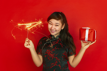 Image showing Happy Chinese New Year. Asian young girls\'s portrait isolated on red background