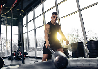 Image showing The male athlete training hard in the gym. Fitness and healthy life concept.