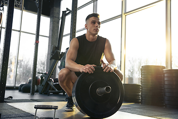 Image showing The male athlete training hard in the gym. Fitness and healthy life concept.