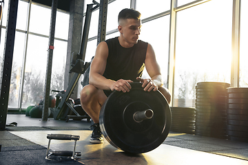 Image showing The male athlete training hard in the gym. Fitness and healthy life concept.