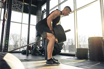 Image showing The male athlete training hard in the gym. Fitness and healthy life concept.