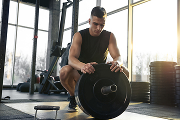 Image showing The male athlete training hard in the gym. Fitness and healthy life concept.