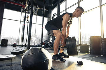 Image showing The male athlete training hard in the gym. Fitness and healthy life concept.