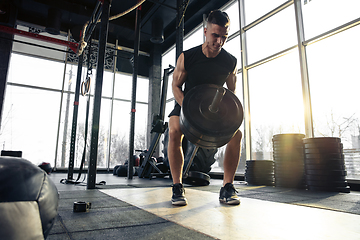 Image showing The male athlete training hard in the gym. Fitness and healthy life concept.