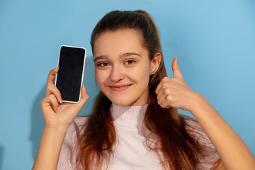 Image showing Caucasian teen girl portrait isolated on blue studio background