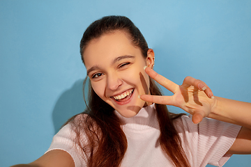 Image showing Caucasian teen girl portrait isolated on blue studio background