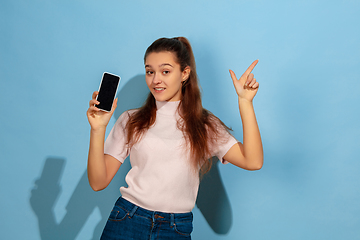 Image showing Caucasian teen girl portrait isolated on blue studio background