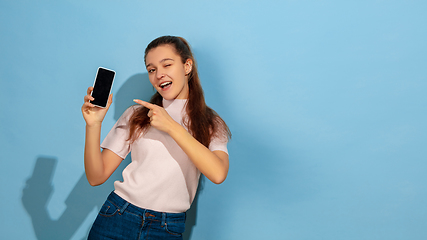 Image showing Caucasian teen girl portrait isolated on blue studio background