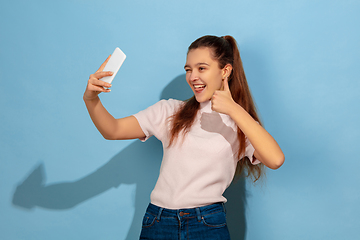 Image showing Caucasian teen girl portrait isolated on blue studio background