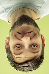 Image showing Inverted portrait of caucasian young man on yellow studio background