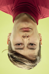 Image showing Inverted portrait of caucasian young man on yellow studio background