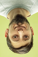 Image showing Inverted portrait of caucasian young man on yellow studio background