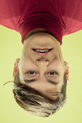 Image showing Inverted portrait of caucasian young man on yellow studio background