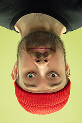 Image showing Inverted portrait of caucasian young man on yellow studio background