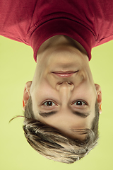 Image showing Inverted portrait of caucasian young man on yellow studio background