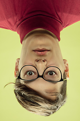 Image showing Inverted portrait of caucasian young man on yellow studio background