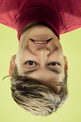 Image showing Inverted portrait of caucasian young man on yellow studio background