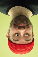 Image showing Inverted portrait of caucasian young man on yellow studio background