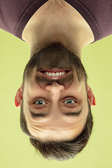 Image showing Inverted portrait of caucasian young man on yellow studio background