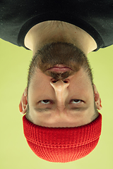 Image showing Inverted portrait of caucasian young man on yellow studio background