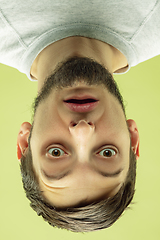 Image showing Inverted portrait of caucasian young man on yellow studio background