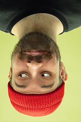 Image showing Inverted portrait of caucasian young man on yellow studio background