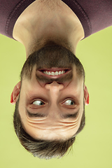 Image showing Inverted portrait of caucasian young man on yellow studio background