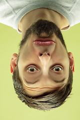 Image showing Inverted portrait of caucasian young man on yellow studio background