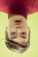 Image showing Inverted portrait of caucasian young man on yellow studio background