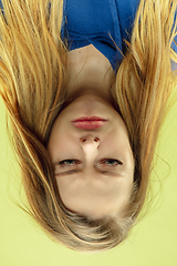 Image showing Inverted portrait of caucasian young woman on yellow studio background