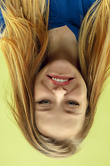 Image showing Inverted portrait of caucasian young woman on yellow studio background