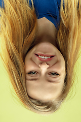 Image showing Inverted portrait of caucasian young woman on yellow studio background