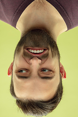 Image showing Inverted portrait of caucasian young man on yellow studio background