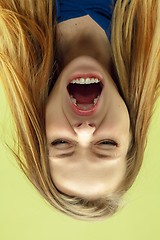 Image showing Inverted portrait of caucasian young woman on yellow studio background